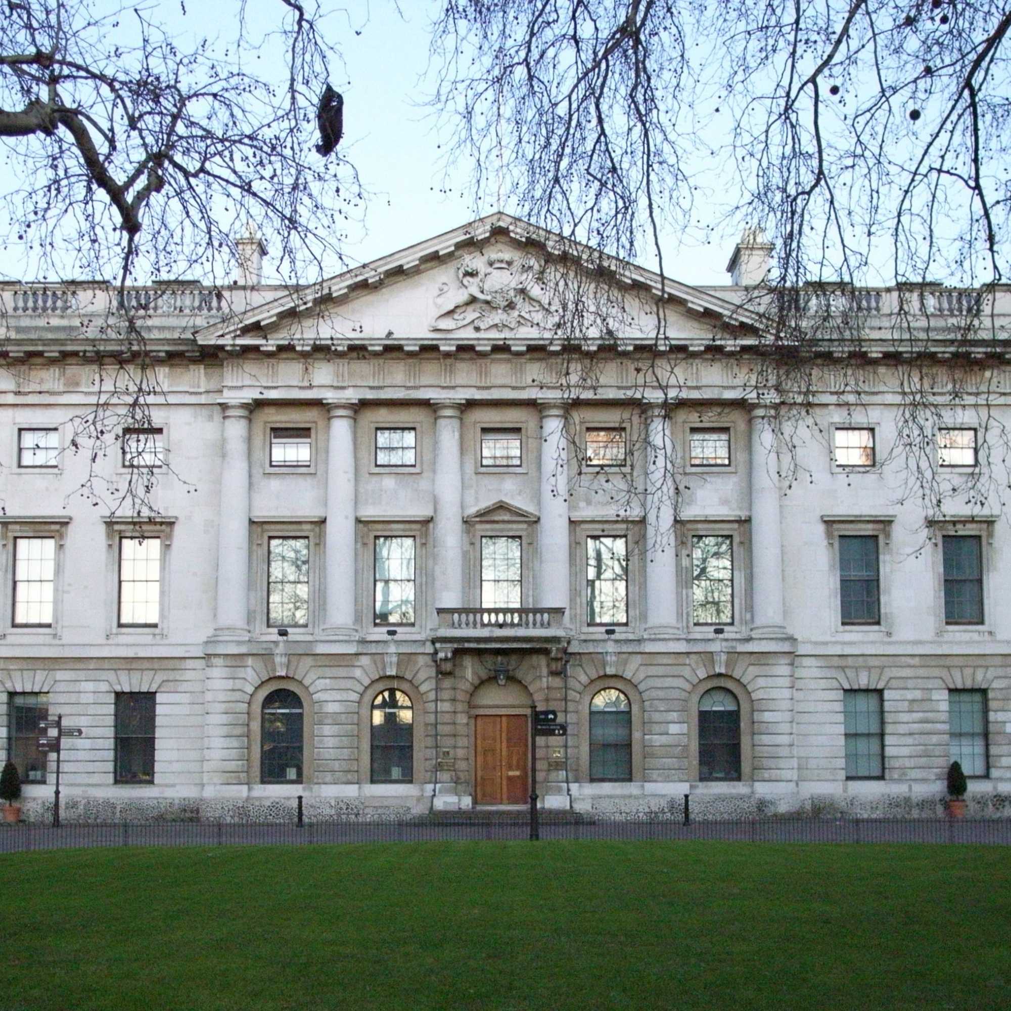 The Royal Mint, a stately white building with classical architecture in a park setting