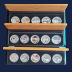 Sets of three times five silver coins from the Perth Mint Discover Australia 2006-2008 series with Australian landmarks in a black case with wooden lid.